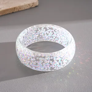 Close-up of a resin bangle featuring irregular holographic geometric flake inclusions