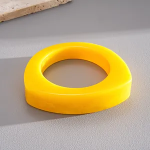 Close-up macro view of bright yellow irregular resin bangle with marbled texture