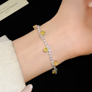 Detailed view of a silver tennis bracelet with yellow and clear cubic zirconia