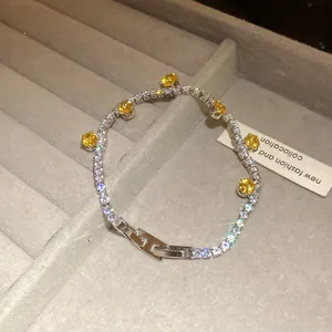 Detailed view of luxury silver tennis bracelet featuring yellow zircons and signature H-clasp