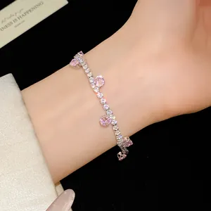 Close-up of elegant silver bracelet featuring sparkling pink zircon stones on wrist.