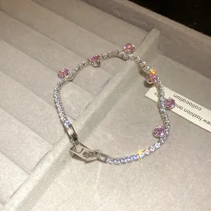 Close-up of zircon bracelet with pink round stones on gray jewelry display tray.