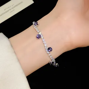 Close-up detail view of an elegant silver zircon bracelet with purple gemstones on a wrist