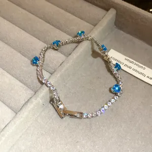 Detailed view of silver-tone tennis bracelet with blue and clear sparkling stones