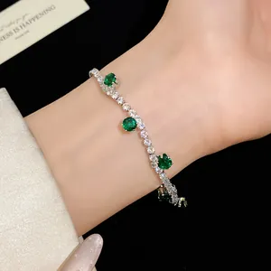 Detail view of sparkling silver zircon tennis bracelet with elegant emerald green stone accents