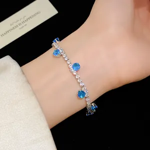 Detailed view of an elegant silver-toned tennis bracelet featuring bright blue round zircons