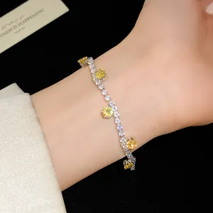 Close-up of elegant silver bracelet with sparkling yellow and clear zircon stones on wrist.