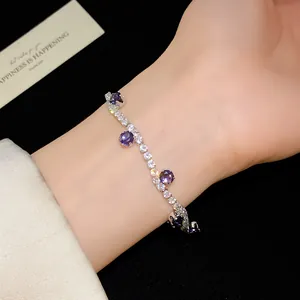 Close-up of a delicate silver-tone bracelet with purple and clear round cubic zirconia.