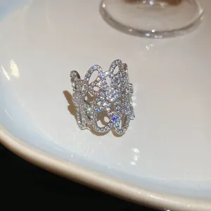 Dettaglio di un anello a fiore traforato color argento con pietre di zircone scintillanti