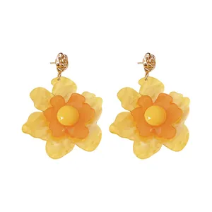 Pendientes de flores de resina amarilla vibrante con cierres de plata para un look de verano