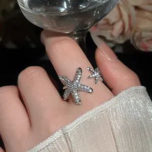 Primo piano elegante di un anello aperto a forma di stella marina con pavé di zirconi
