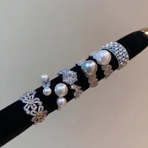 French vintage style zircon flower and pearl open rings displayed on black velvet rod