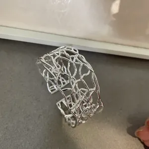 Vista dettagliata del bracciale rigido argento minimalista con motivo a trama scavata