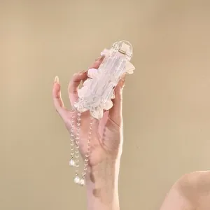 Detailed view of an elegant pink flower hair clip with dangling pearl tassels