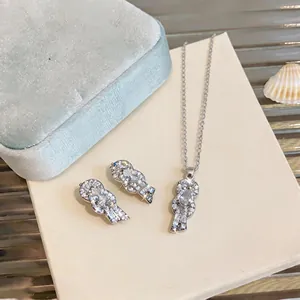 Elegant silver-toned necklace and earrings set featuring sparkling zircon horseshoe knot design.