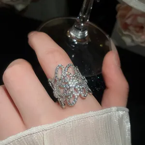 Primo piano di un anello floreale traforato argento con zirconi scintillanti