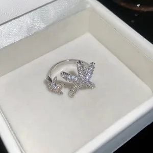 Dettaglio macro dell'anello a stella marina argentato con zirconi in una scatola bianca.