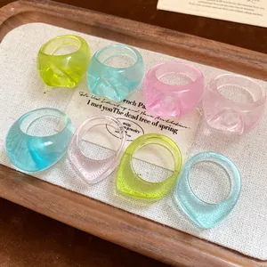 Detailed macro view of colorful irregular translucent resin rings set on a wooden tray