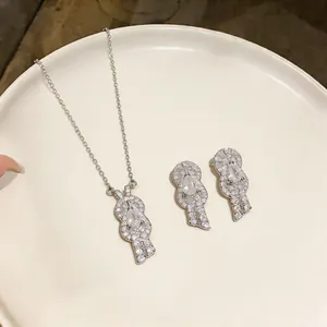 Detailed view of elegant zircon horseshoe buckle necklace and stud earring set on tray