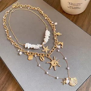 Elegante collana a strati dorata con ciondoli a conchiglia, stella marina e perle
