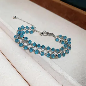 Detailed view of a handcrafted blue beaded hollow bracelet with a silver chain mesh.
