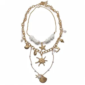 Elegante collana dorata a strati con perle, conchiglie e stelle marine tema oceano