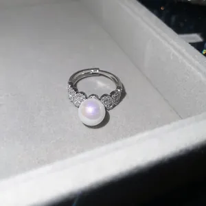 Close-up detail of a French retro zircon pearl open ring resting in a plush jewelry box