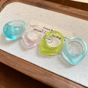 Close-up of four colorful irregular resin rings in a minimalist set for daily jewelry wear.