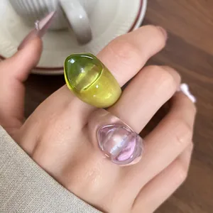 Macro view of two chunky irregular resin rings in green and clear pink colors