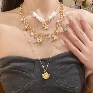 Vista dettagliata di una collana a strati con conchiglie dorate, stelle marine e perle
