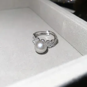 Close-up of a silver pearl ring with sparkling zircon flowers in a luxury velvet jewelry box