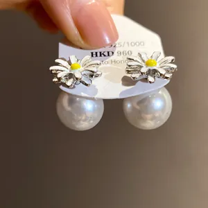 Dettaglio degli orecchini a margherita con grandi perle bianche e perni in argento S925.