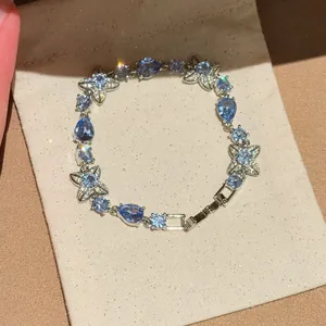 Detailed view of silver-toned bracelet with blue zircon flowers and teardrop stones