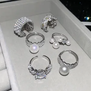 Macro view of French vintage style zircon and pearl open rings set in a jewelry tray