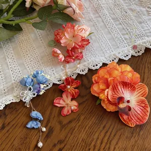 Eleganti fermagli per capelli a fiori in tessuto con perle su uno sfondo di pizzo bianco
