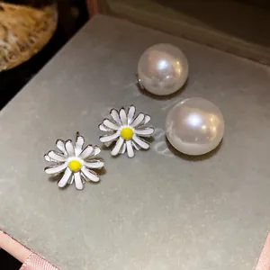 Dettaglio di orecchini a lobo a margherita in argento con perle in una scatola regalo
