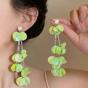 Dettaglio di orecchini a nappa con petali verdi in stile coreano eleganti e perle.