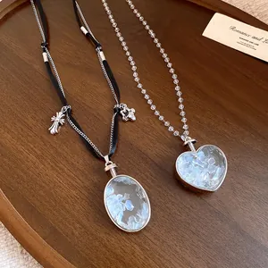 Dettaglio di collane con ciondoli a cuore e ovali con frammenti di pietre blu all'interno