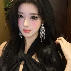 Model wearing long pearl tassel earrings with vintage french luxury style details
