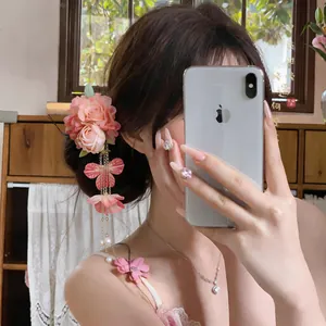 Elegante fermaglio per capelli a fiori rosa con nappa di perle su capelli castani