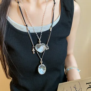 Collana a strati con ciondoli a cuore e ovali con cristalli blu indossata da modella