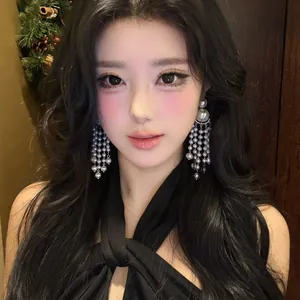 Elegant silver-toned pearl tassel earrings worn by an Asian model in a stylish setting