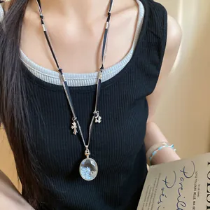 Primo piano dettagliato di una collana di moda con pendente in cristallo e ciondoli.