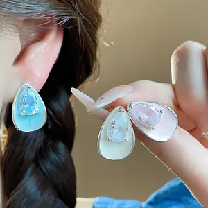 Close-up detail of water drop earrings with zircon stones and colorful enamel finishes