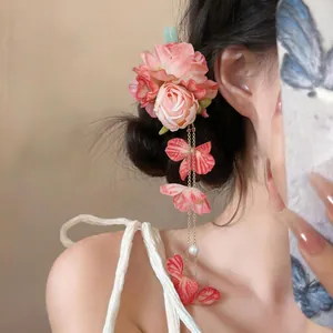 Dettaglio di un'elegante fermaglio per capelli in tessuto rosa con nappe di perle