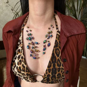 Collar bohemio multicapa con cuentas facetadas iridiscentes lucido por una modelo.