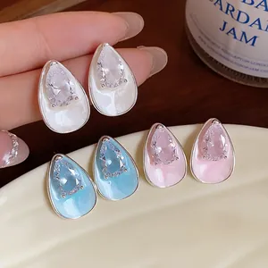 Detailed macro view of teardrop zircon stud earrings with enamel finish in various colors