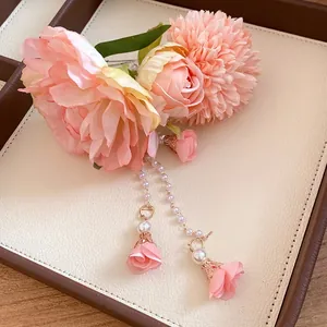 Elegante fermaglio per capelli con fiori in tessuto e lunghe nappe di perle rosa donna.