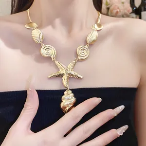 Close-up of an elegant gold starfish and shell pendant necklace worn by a female model