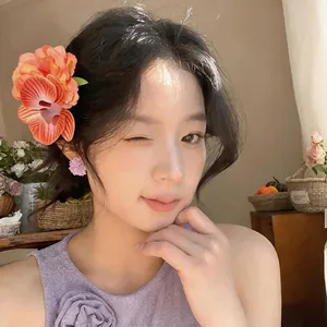 Dettaglio di elegante fermaglio per capelli con fiori in tessuto indossato da una modella
